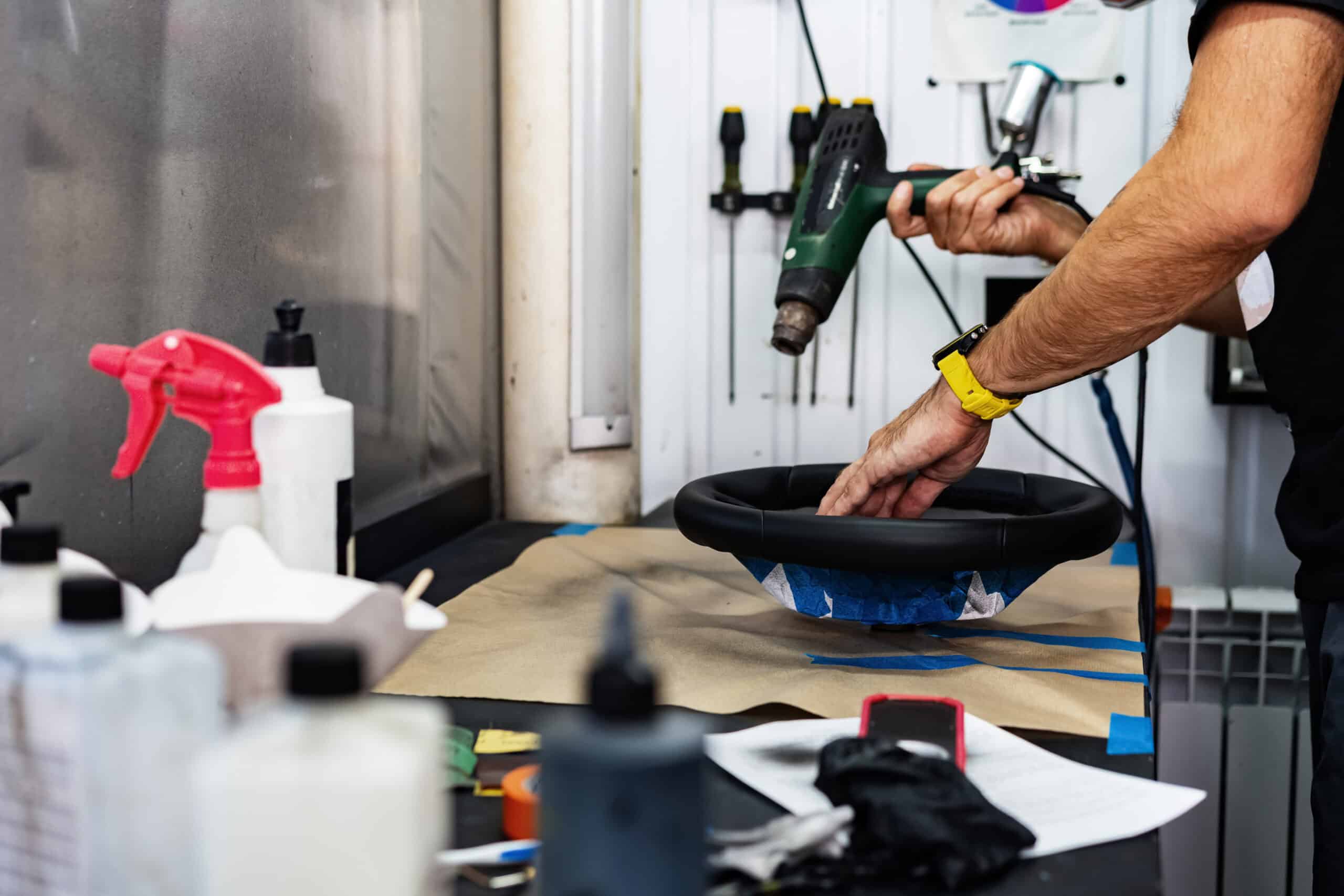 Mann, der in einer Autopflegewerkstatt arbeitet, repariert ein Lederlenkrad, Nahaufnahme